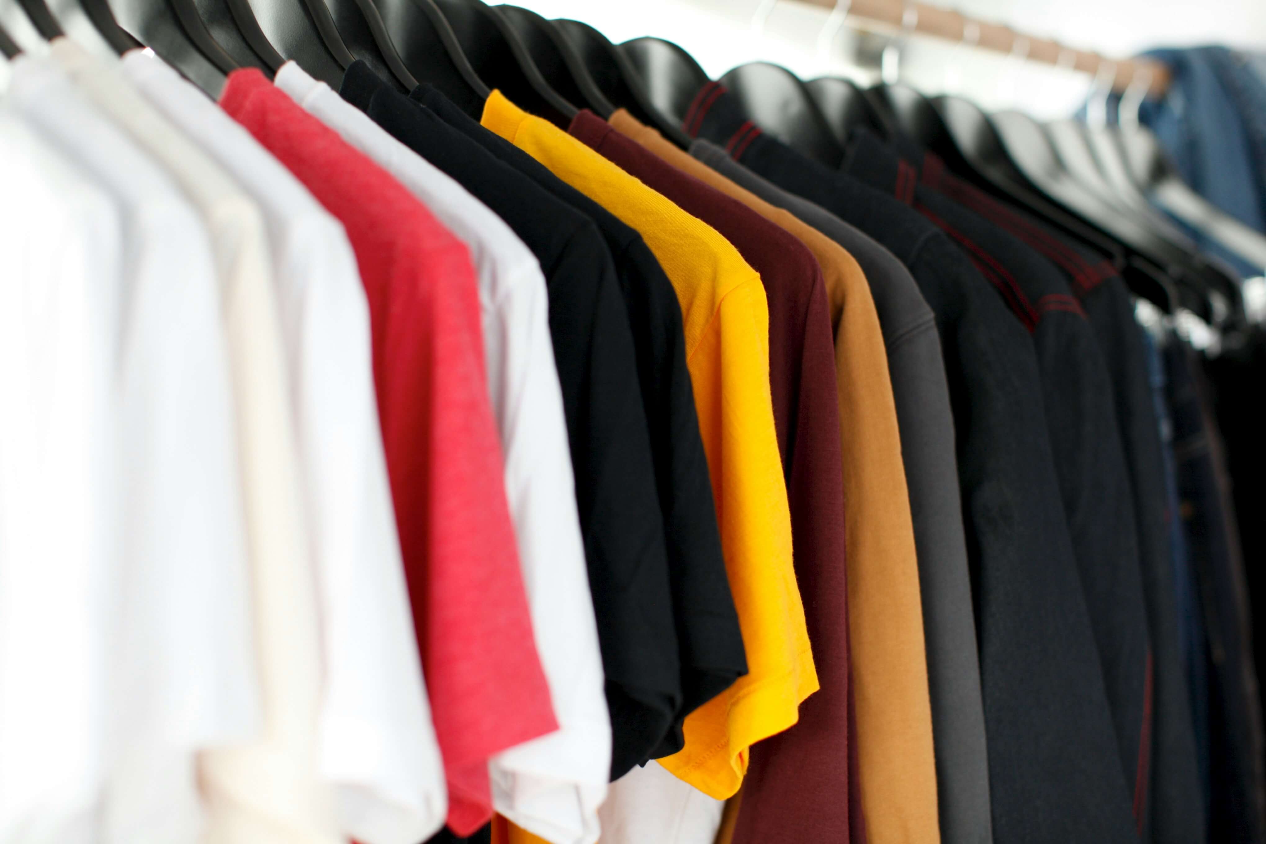 A cloth rack with multiple t-shirts. loading=lazy